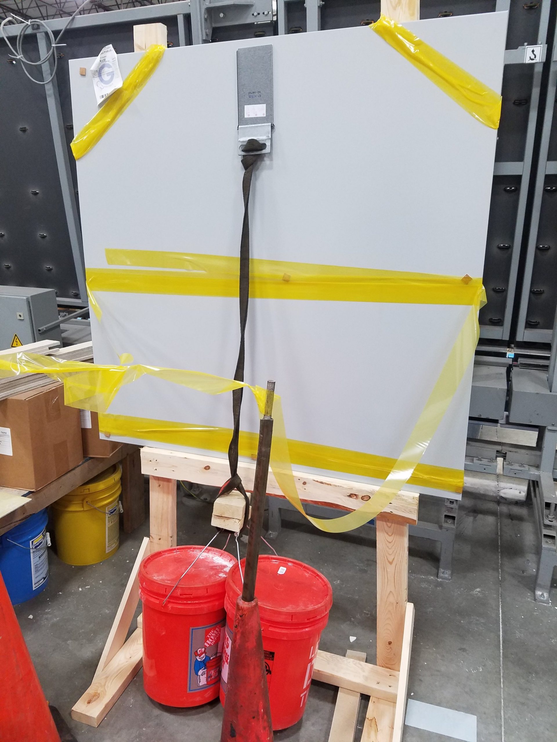 Bracket load test in the shop Shop load test of a hanging bracket bonded to a back painted glass panel, with a strap and two buckets of weight on an A-frame